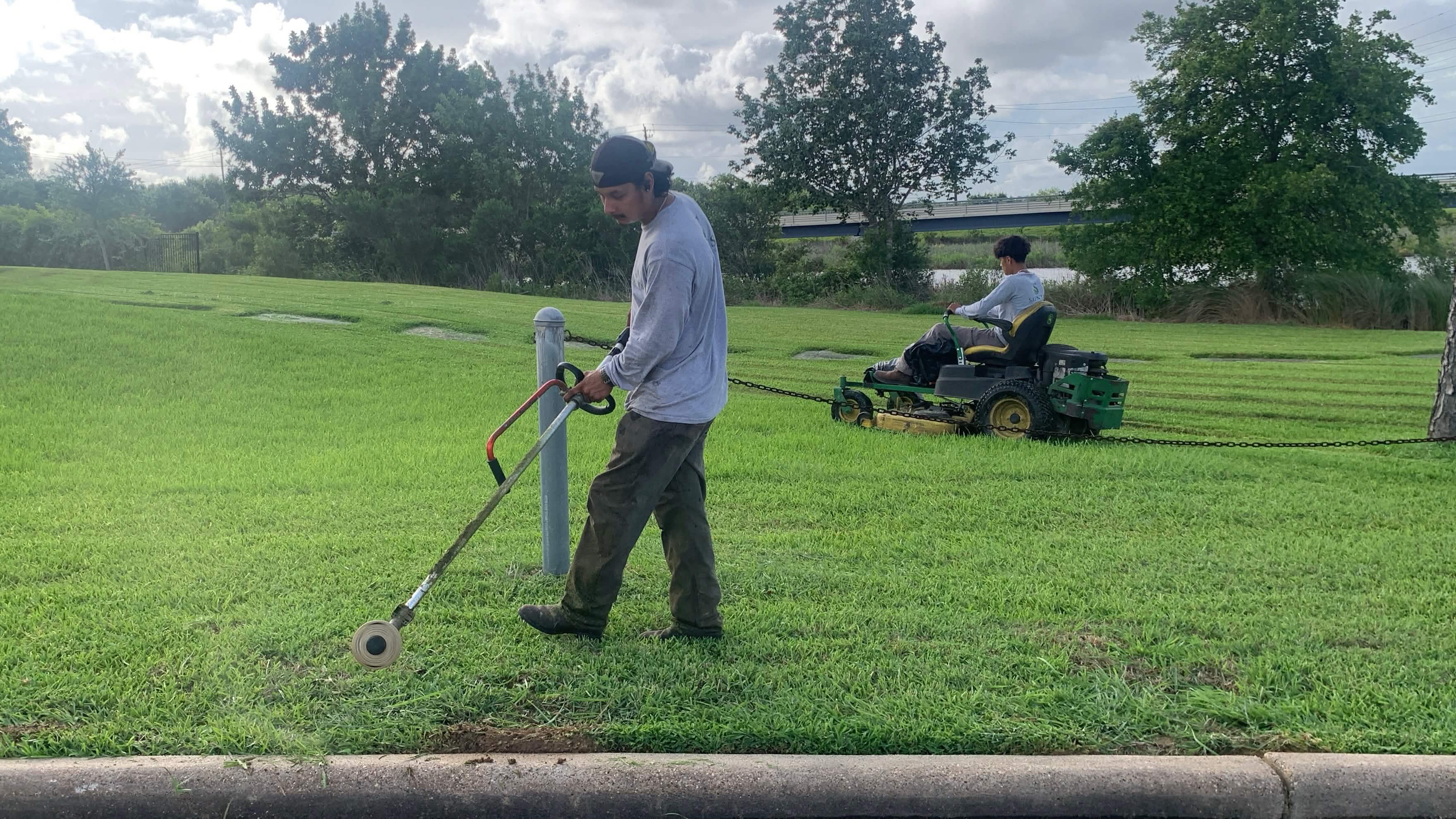 Saints Lawn Maintenance crew edging and mowing a clean green lawn