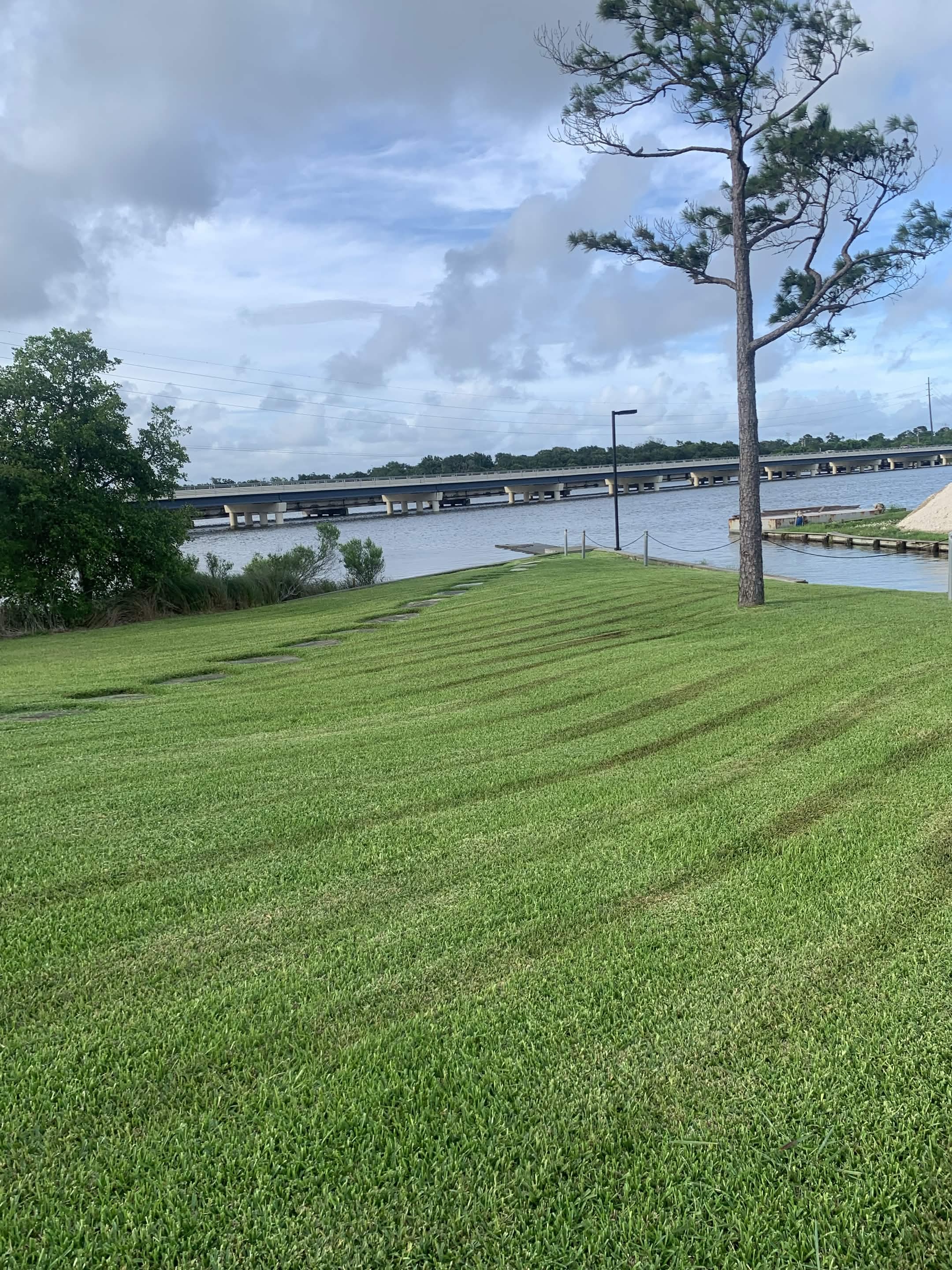 Freshly maintained lawn with clean mowing lines near the water